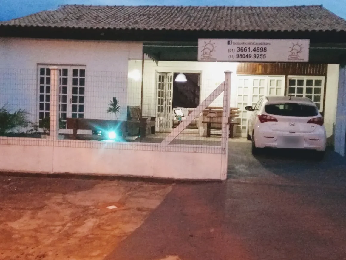 Pousada Casa da Barra ao entardecer, com estacionamento fechado e varanda iluminada